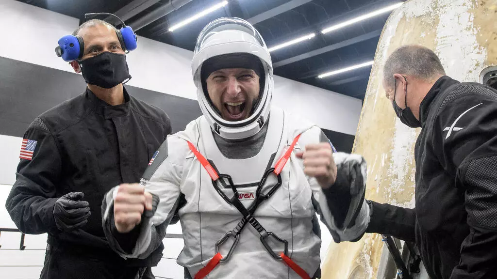 El astronauta de la NASA Mike Hopkins reacciona mientras es ayudado a salir de la nave espacial Crew Dragon Resilience de SpaceX.