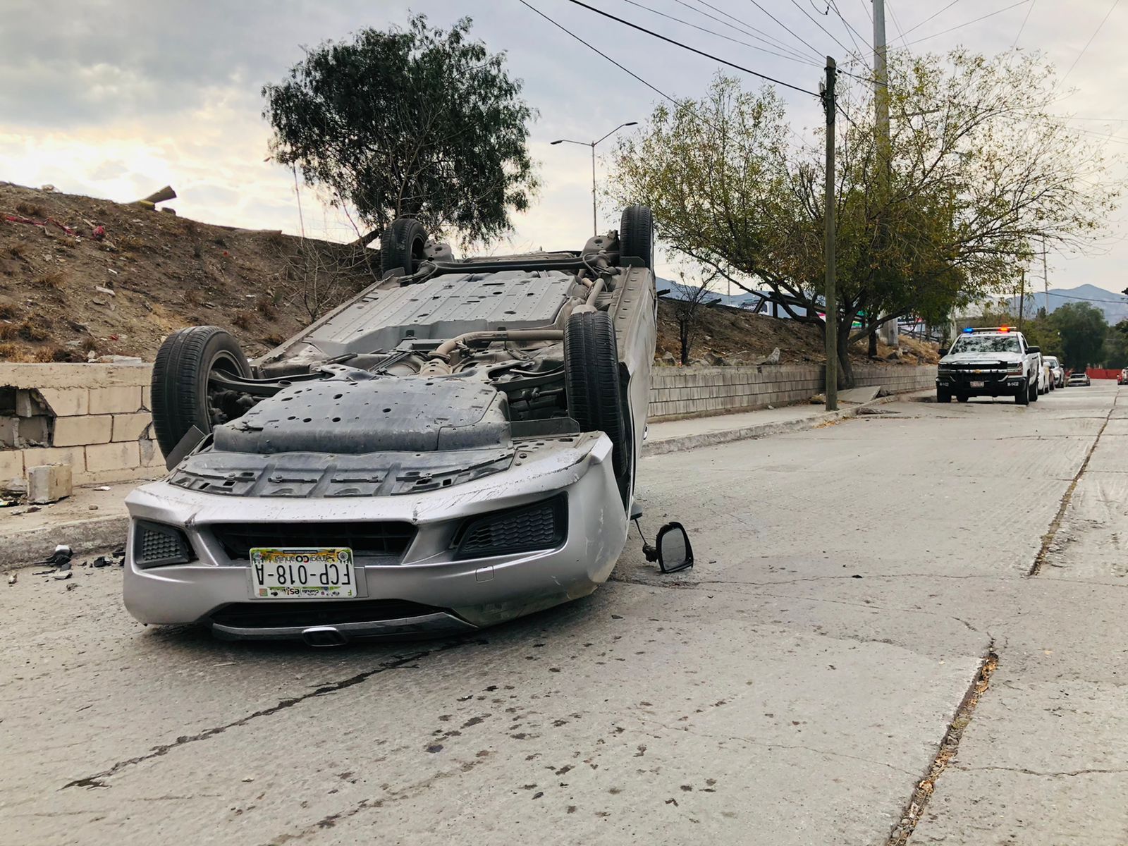 Cae y vuelca por exceso de velocidad